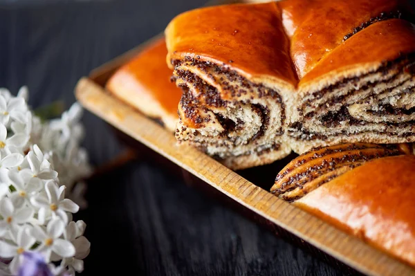 Poppy seed roll , juicy and appetizing.Sprig of lilac. Tea party — Stock Photo, Image