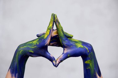 Sarı aksanlı mavi boyalı eller, sanatçının elleri ve yaratıcı kişi. Eller için Yoga