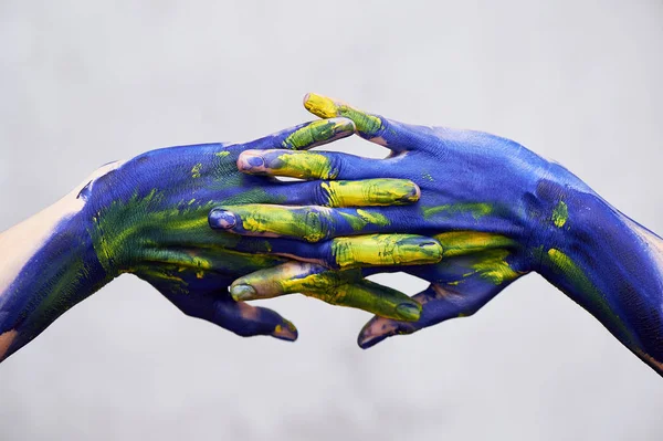 Mani in vernice blu con accenti gialli, mani dell'artista e persona creativa.Yoga per le mani — Foto Stock