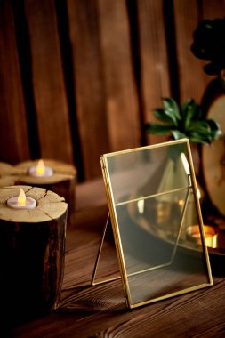 Altın çerçeve, küçük kütükler içinde led mumlar. Rahat dekor.