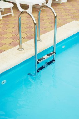Havuzda Metal korkuluklar. Suya iniş. Tatil, dinlenme ve rahatlama