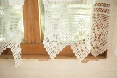 A window in a whitewashed hut with a wooden frame, a Lacy linen starched curtain.The interior of the house. Ukraine, the Cossacks clipart