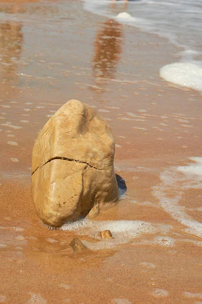 Pierre avec fissures sur le sable. Côte de la mer. Vague — Photo