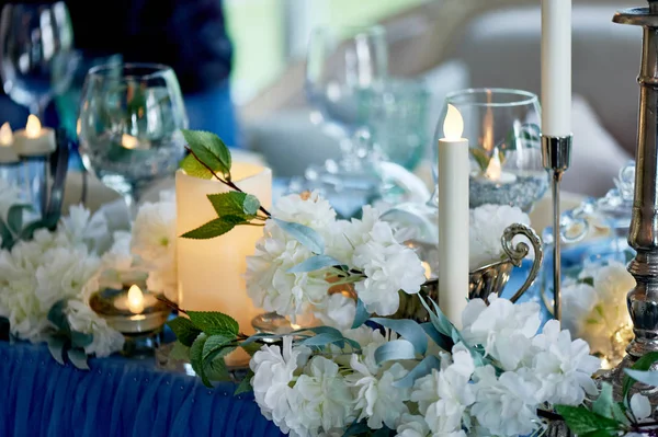 Svatební stolek zdobený bílými květinami, svíčkami... Modrá a bílá. — Stock fotografie