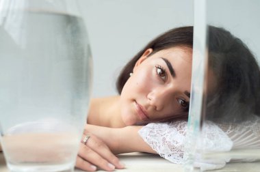 Koyu kaşlı, kahverengi gözlü ve koyu saçlı bir kız. Doğal güzellik. Kalın geniş kaşlar. Su ile kaplar. Doğal güzellik