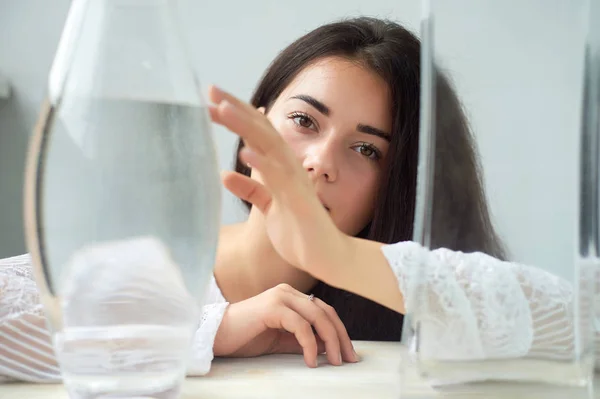 Una chica con cejas oscuras, ojos marrones y cabello oscuro. Belleza natural. Cejas gruesas y anchas. Buques con agua. Belleza natural —  Fotos de Stock