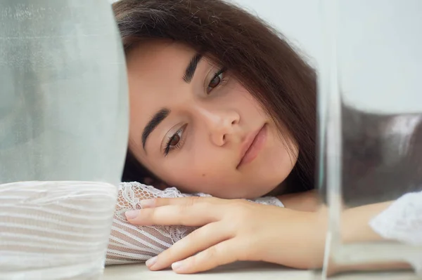 Una chica con cejas oscuras, ojos marrones y cabello oscuro. Belleza natural. Cejas gruesas y anchas. Buques con agua. Belleza natural —  Fotos de Stock