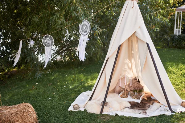 Boho tarzı, düğün dekorasyonu. Kolaylık ve basitlik. Keten bir bezle kaplı bambu bir kulübe. Dekoratif bir yer. Açık hava eğlencesi. Glamping