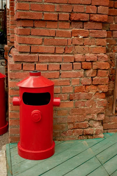 The garbage container is metallic red in a loft-style space on the street — ストック写真