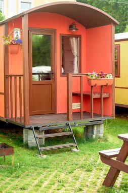 Doğada kamp. Tekerlekli çok renkli evler. Rahat koşullarda doğada dinlen..