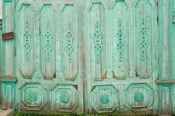 Puertas anchas de madera en antiguas casas rusas. Adornos figurativos de madera.Colores brillantes. Antiguas casas rusas de madera. — Foto de Stock
