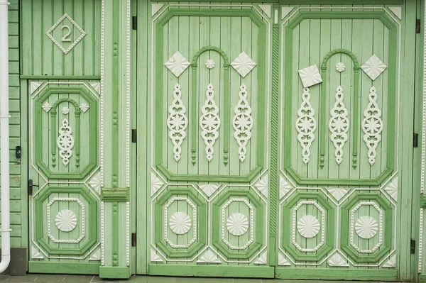 Puertas anchas de madera en antiguas casas rusas. Adornos figurativos de madera.Colores brillantes. Antiguas casas rusas de madera. — Foto de Stock