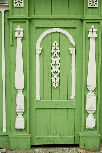 Viejas puertas de madera decoradas con figurillas talladas en madera. Una antigua casa rusa.Centro histórico. — Foto de Stock