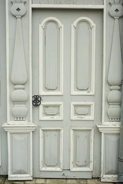 Viejas puertas de madera decoradas con figurillas talladas en madera. Una antigua casa rusa.Centro histórico. — Foto de Stock