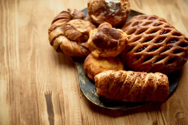 Bake on a plate. On a wooden background.Free space for text on the left. A wicker with jam. — Stock Photo, Image