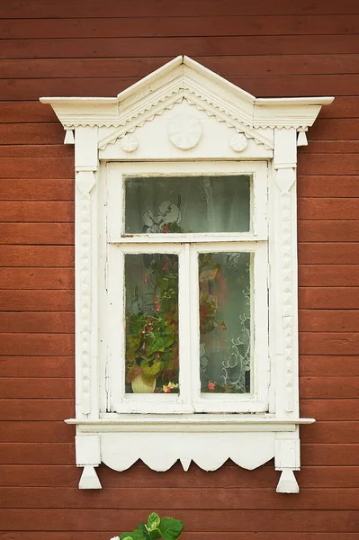 Eski ahşap bir Rus evinde fayanslı bir pencere. Tarih merkezi. Güzel bir pencere tasarımı..