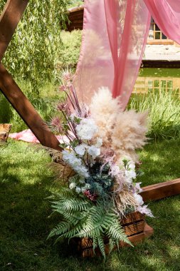 Çıkış girişindeki düğün odununun kemerinin bir parçası. Doğada düğün. Pampa, eğrelti otu ve kurumuş çiçeklerden oluşan bir kompozisyon..