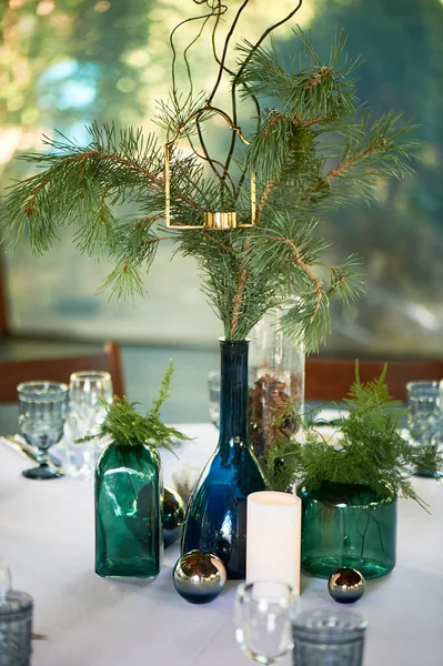 Éttermi kialakítás.Egy asztal fehér terítővel, klasszikus tálalással. Egy üveg kék és zöld üveg. A mancsok ettek.. — Stock Fotó