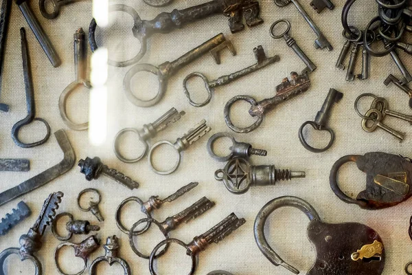 Oude kastelen en sleutels onder het glas in het museum.Het is een smederij. — Stockfoto
