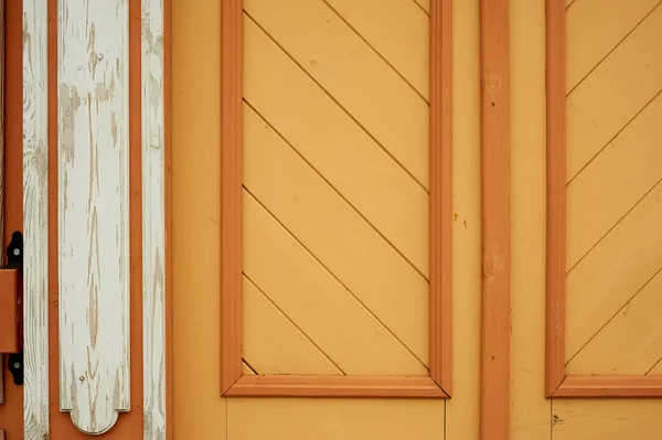 De textuur van de omheining of deur.Een oud houten huis. Een oranje-gekleurde schuine. — Stockfoto