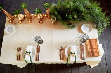 Gelin ve damatlar masa. Yukarıdan bakın. Altın kaplar ve ladin pençeleri ile süslenmiş. Eko biçimi.