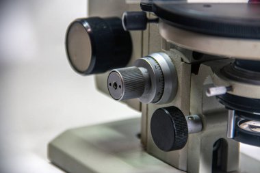 Close-up of the knobs and controls of an old microscope