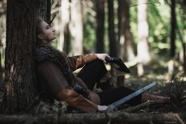 Viking kadın kılıçla geleneksel savaşçı kıyafetlerle derin gizemli bir ormanda