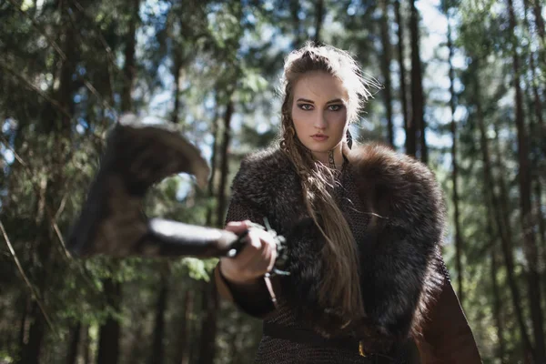 Viking kadın geleneksel savaşçı kıyafetlerle derin gizemli bir ormanda çekiç ile