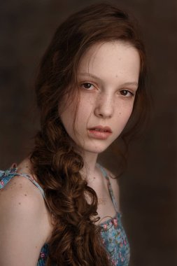 Dramatik bir genç şirin kızıl saçlı Genç kız stüdyoda kıvırcık saç kesimi ile portresi