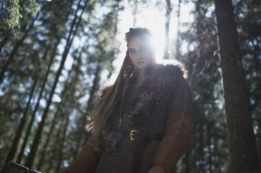 Geleneksel savaşçı kıyafetlerle derin gizemli bir ormanda Viking kadın