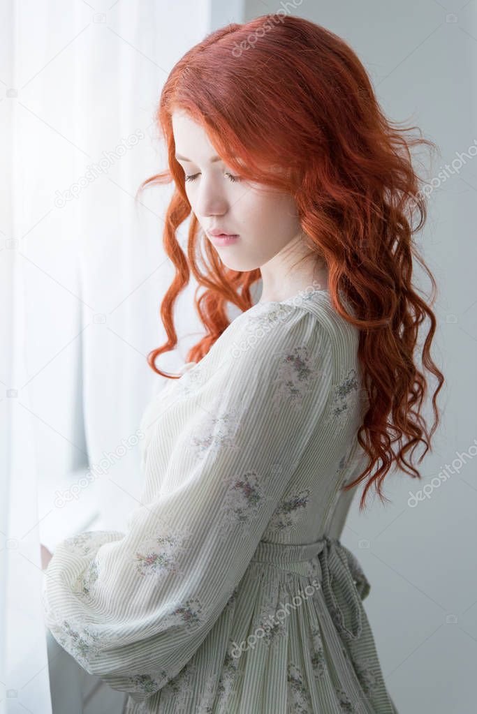 Tender retro portrait of a young beautiful dreamy redhead woman