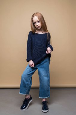 Güzel genç Kızıl saçlı kız kot pantolon ve kazak stüdyo çekim