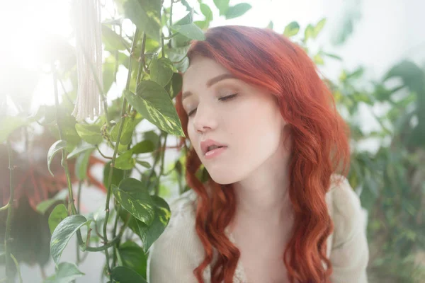 一个年轻美丽的梦幻般的红头发的女人在树叶的肖像 — 图库照片