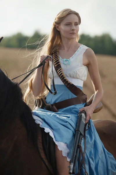 Güzel bir kadın kovboy kız vahşi batıdan outback bir at binme av tüfeğiyle portresi