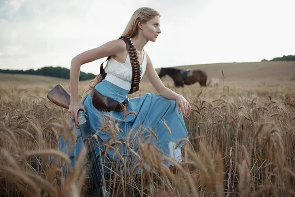 一个美丽的女子女牛仔与猎枪从野生西部骑马在内陆的画像 — 图库照片