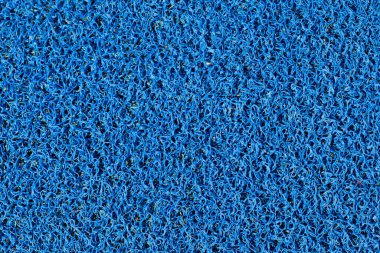 Mavi, yoğun bir şekilde paketlenmiş, halkalı bir paspasın yakın çekimi. Doku tüm çerçeveyi dolduruyor..