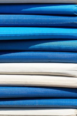 Mavi ve beyaz yastıklara yakın çekim. Doku ve renk değişimlerine odaklanarak çizgili bir etki yaratır..