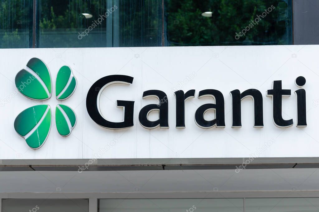 A close-up of the Garanti BBVA bank sign. It features a four-leaf clover and the bank's name on a white background.