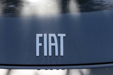 Koyu renkli bir arabanın arka tarafında büyük, gümüş ve tıkanmış harflerle 