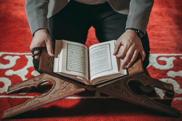 Muslim man praying and reading holy book