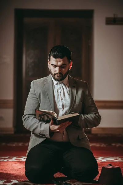イスラム教徒の男性が祈りとの神聖な本を読む — ストック写真