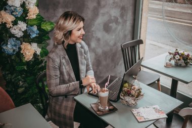 Dizüstü bilgisayar ve içecek kahve yazarak kız