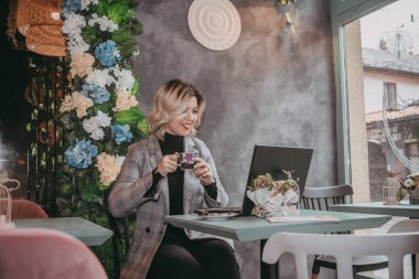 Dizüstü bilgisayar ve içecek kahve yazarak kız