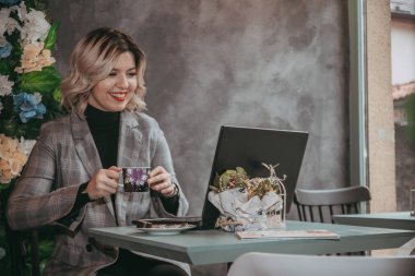 Dizüstü bilgisayar ve içecek kahve yazarak kız