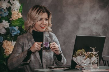 Dizüstü bilgisayar ve içecek kahve yazarak kız