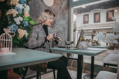 Dizüstü bilgisayar ve içecek kahve yazarak kız