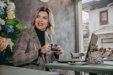 Dizüstü bilgisayar ve içecek kahve yazarak kız