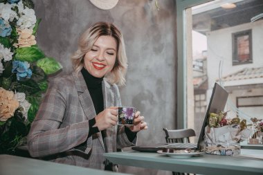 Dizüstü bilgisayar ve içecek kahve yazarak kız