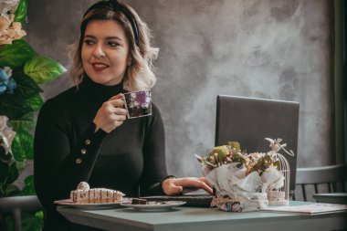 Dizüstü bilgisayar ve içecek kahve yazarak kız