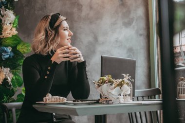 Dizüstü bilgisayar ve içecek kahve yazarak kız